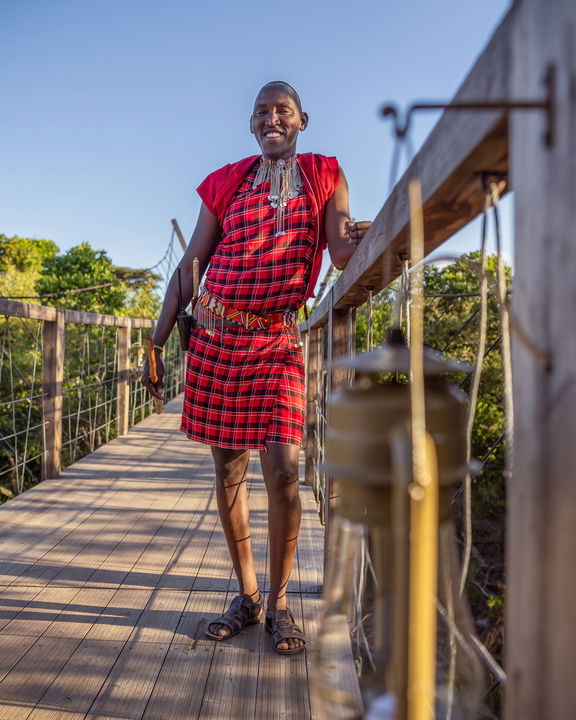 masai man standing on bridge of the JW Marriot Masai Mara Kenya