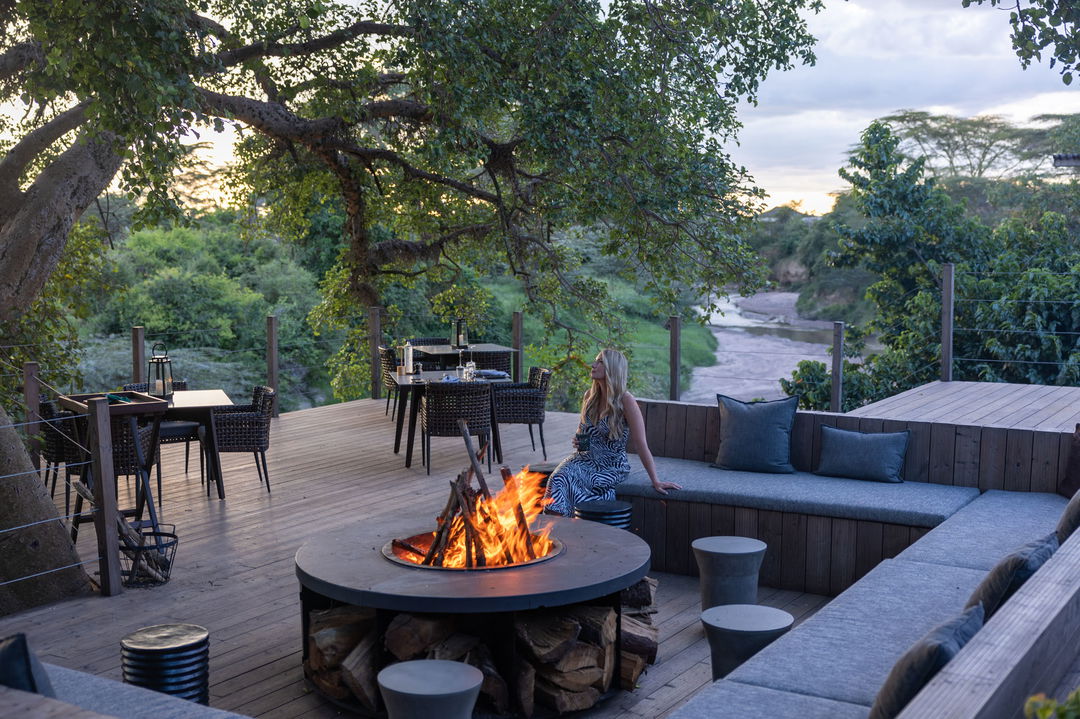 view of the firepit with lady guest on the deck of the JW Marriot Masai Mara Kenya