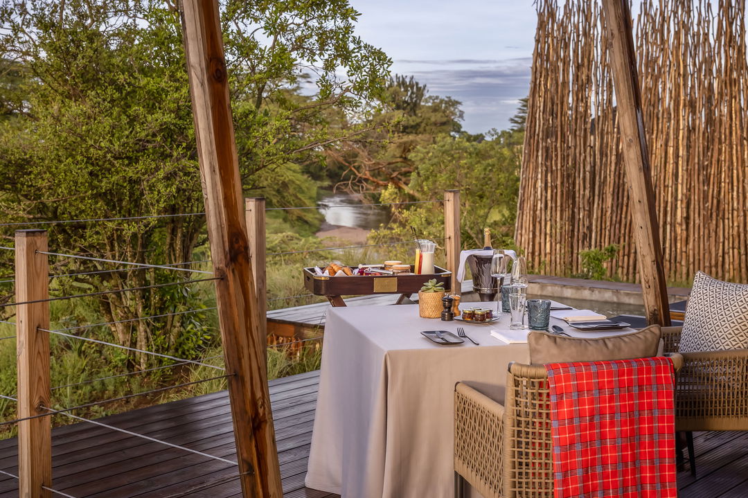 table set for breakfast on the deck of a honeymoon suite at the JW Marriot Masai Mara Kenya