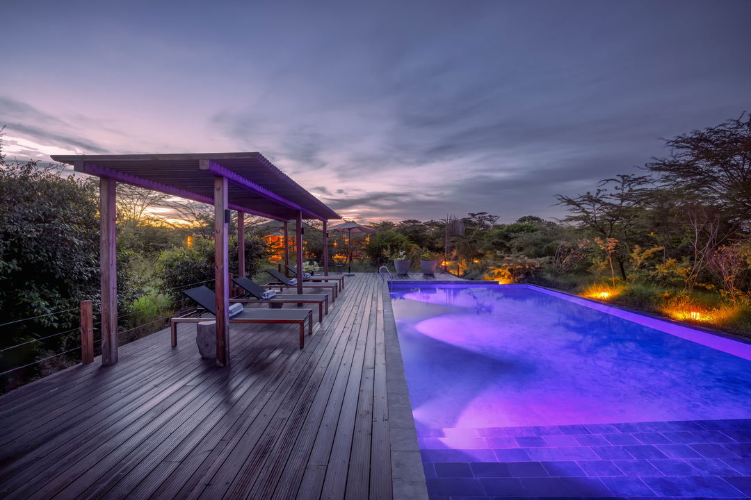 evening view with illuminated main swimming pool at the JW Marriot Masai Mara Kenya