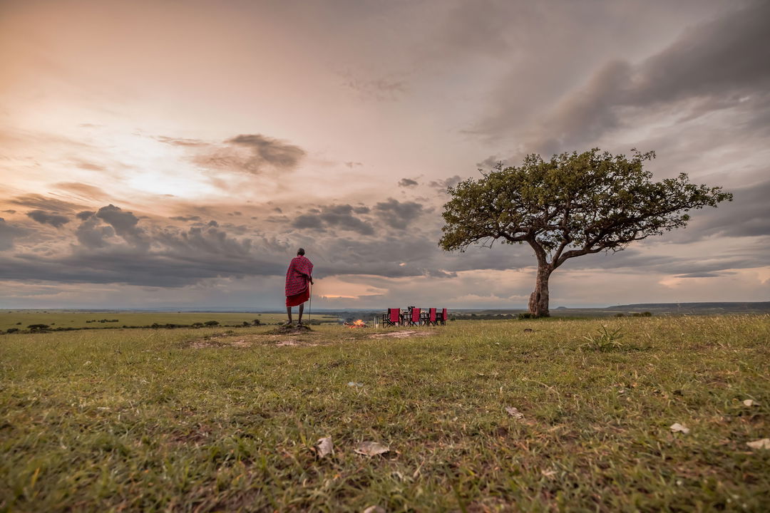 sundowners on the plains of the mara with a masai man at the JW Marriot Masai Mara Kenya