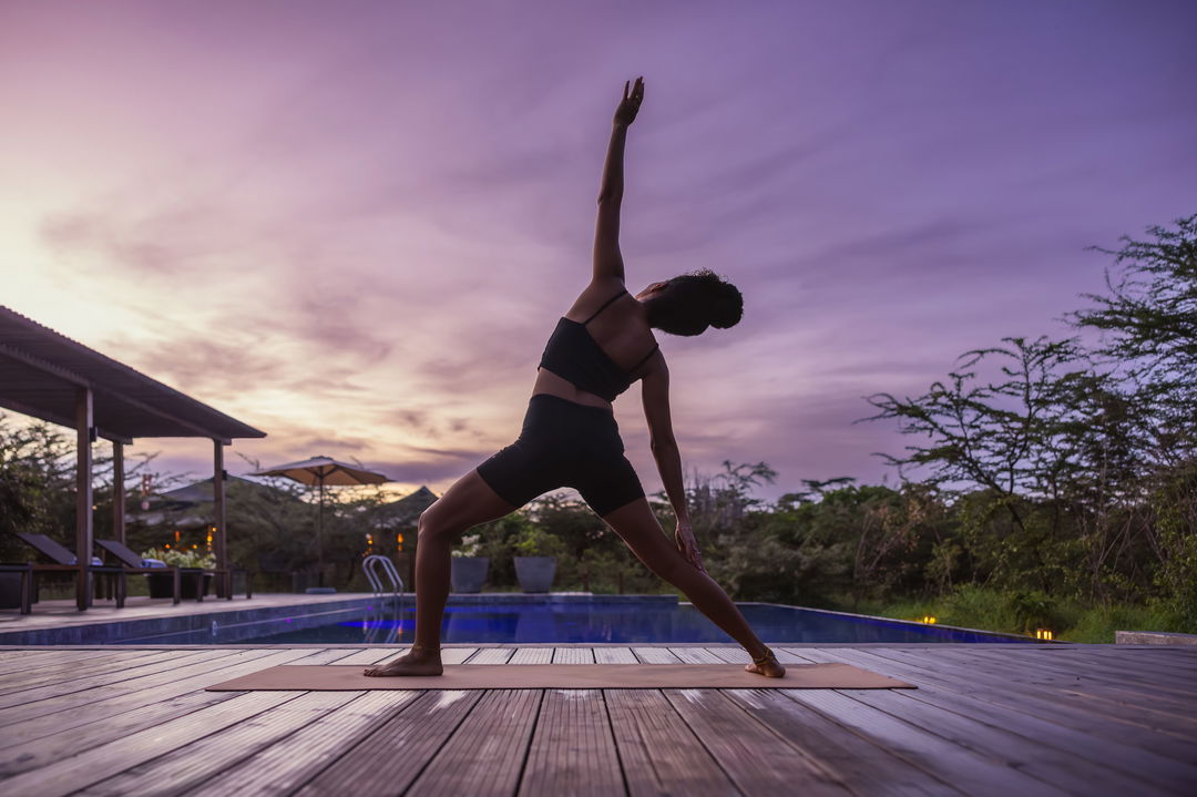 guest doing yaga on the deck of the JW Marriot Masai Mara Kenya