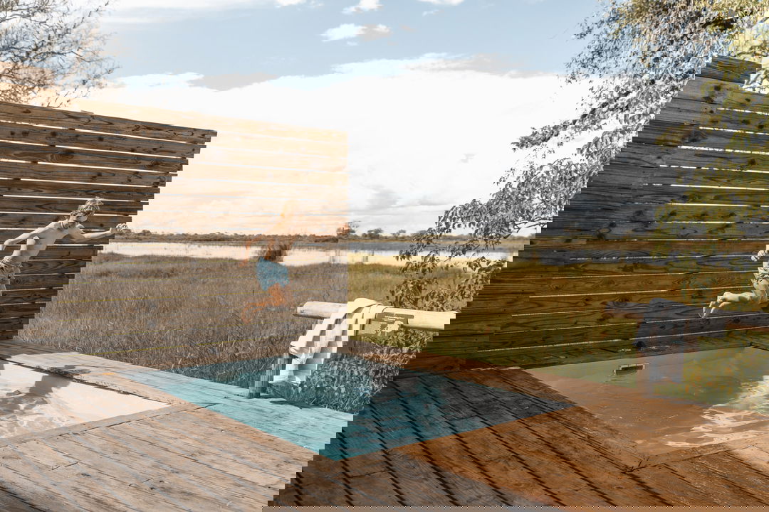 kid jumping into splash pool on room deck at Vumbura Plains Camp Wilderness Okavango Delta