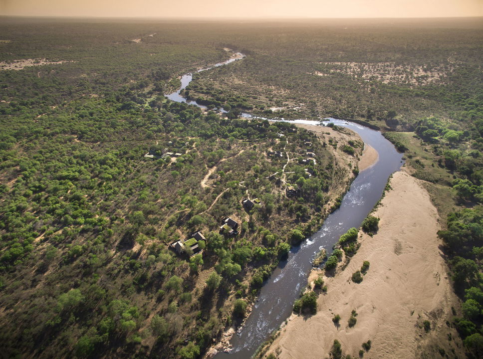 aerial view of lion sands ivory lodge next to river