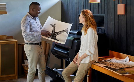 staff and guest looking at giraffe conservation images in creative lab lion sands