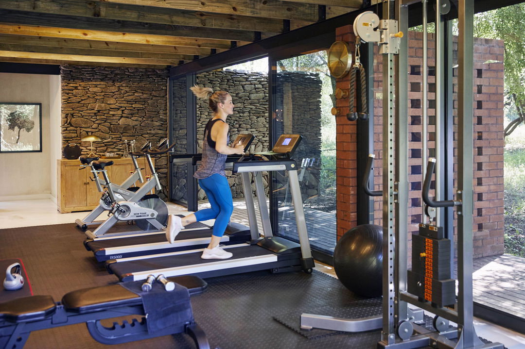 lady guest running on treadmill in gym of river lodge lion sands