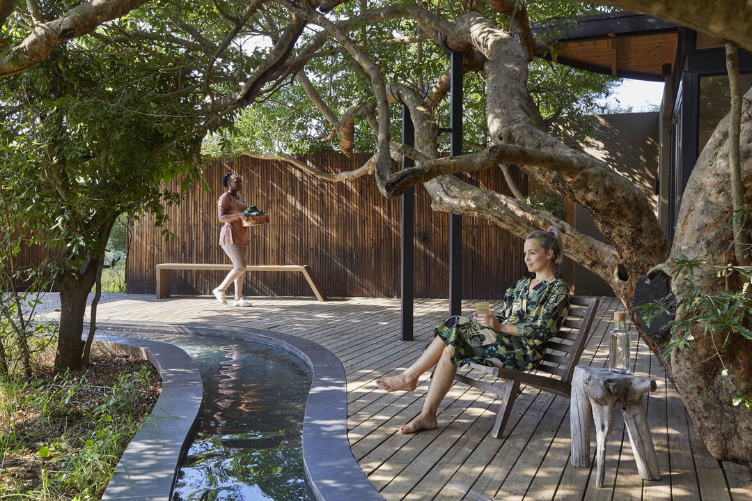 lady guest on chair in front of spa at river lodge lion sands