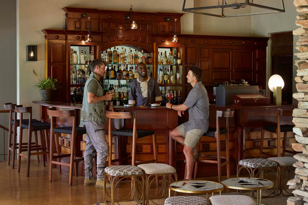 two male guests having drinks at bar of Tinga lodge lion sands 