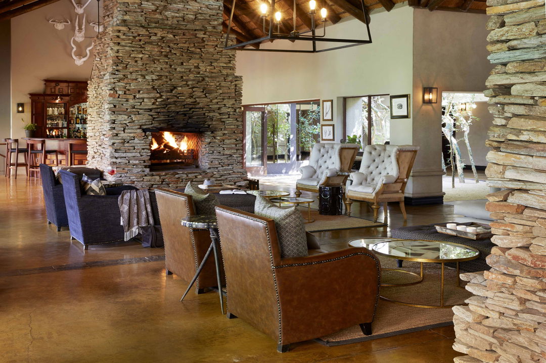 chairs by fireplace in lounge of Tinga lodge lion sands