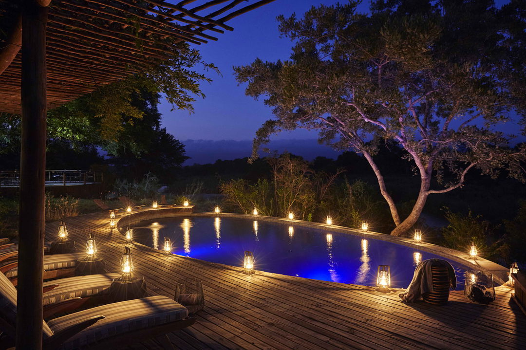 view of main lodge pool at night by Tinga lodge lion sands