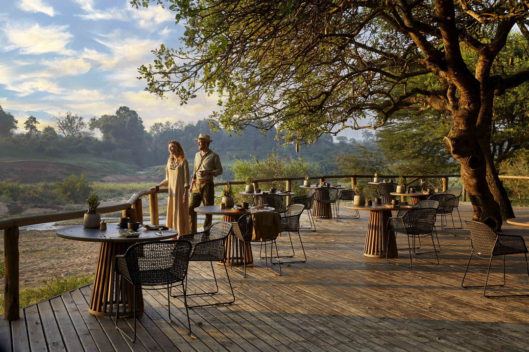 couple on deck with river view at ivory lodge by Lion Sands Game Reserve
