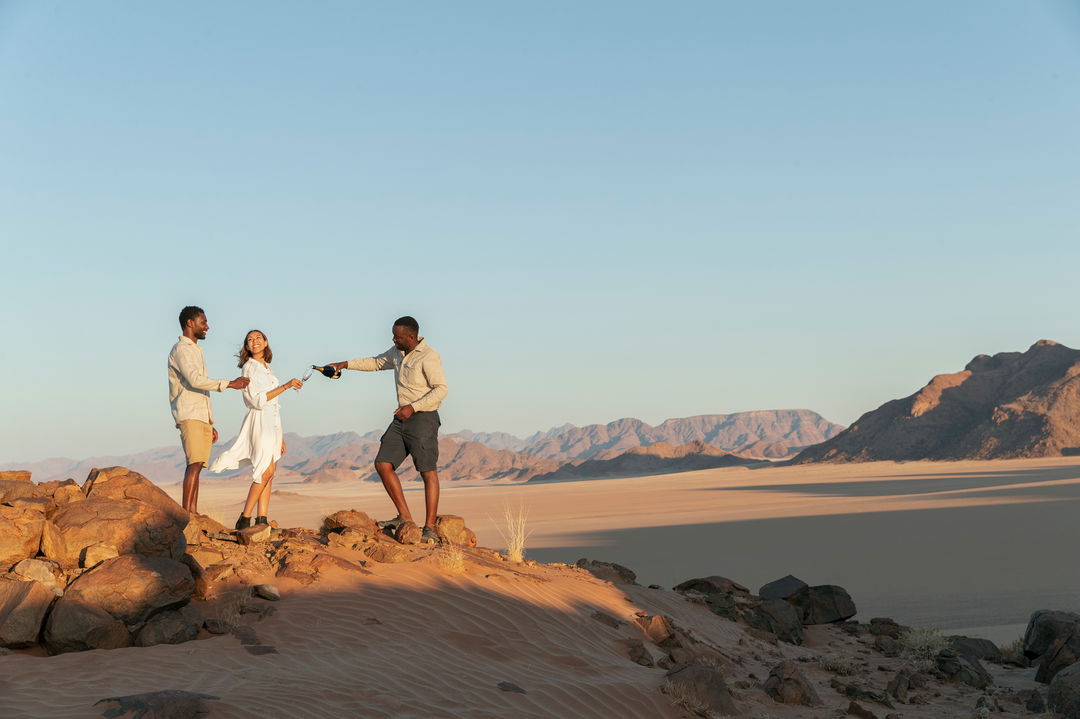 sundowners with guide on rocky outcrop at little Kulala camp wilderness Namibia