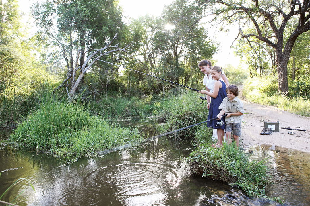 kids fishing in river by Londolozi game reserve