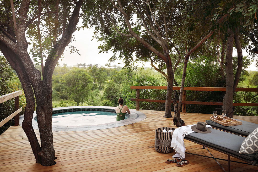 lady in splash pool on private deck of pioneer camp Londolozi