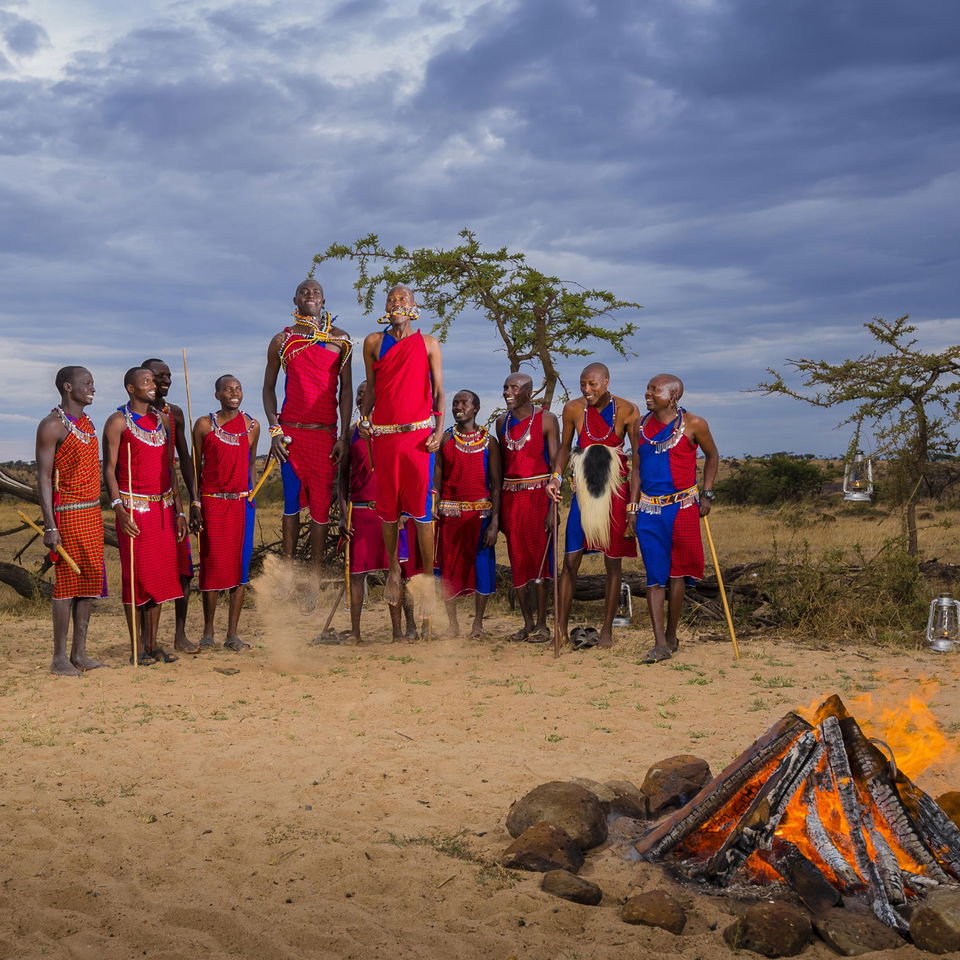 Masai men by fireplace jumping at Mahali Mzuri Kenya Masai Mara