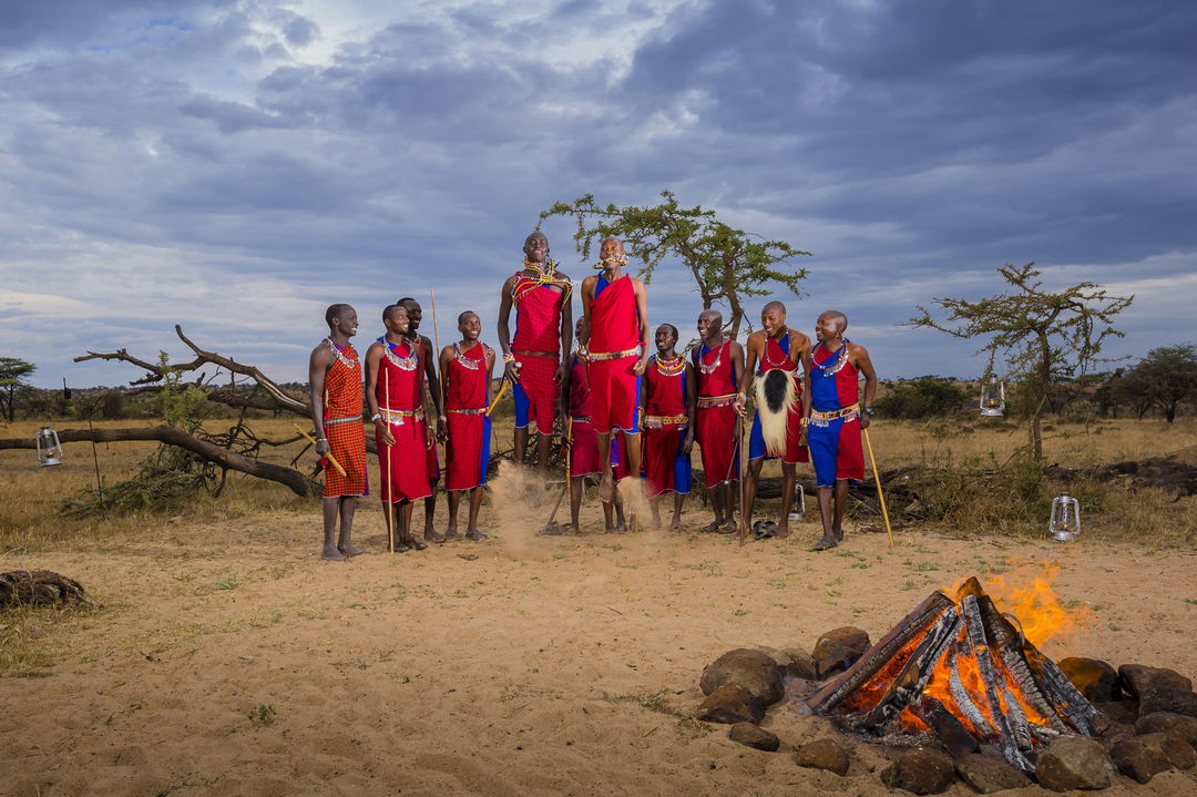 Masai men by fireplace jumping at Mahali Mzuri Kenya Masai Mara