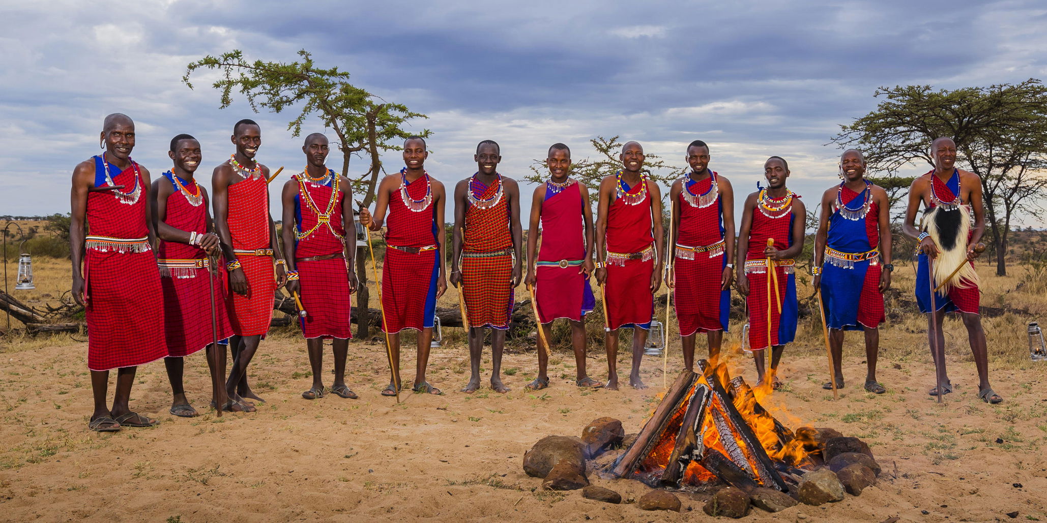 Masai men standing by fire to entertain guests at Mahali Mzuri Kenya Masai Mara
