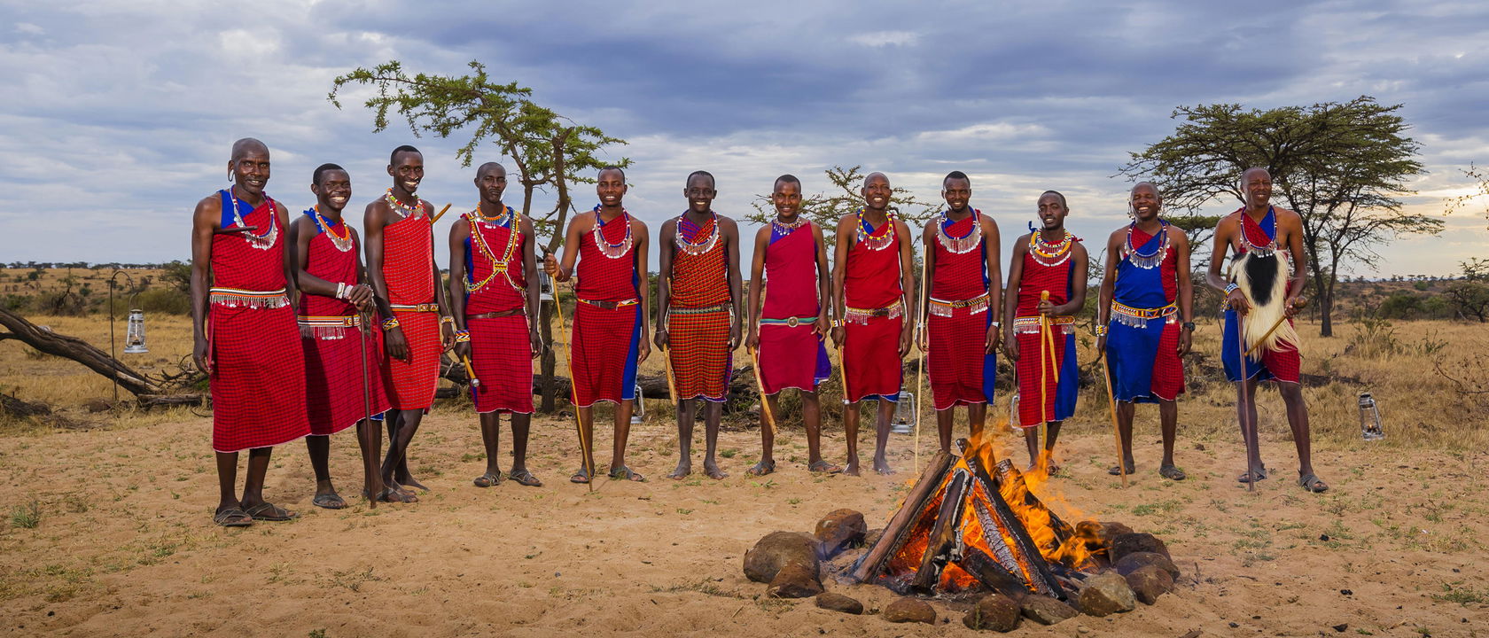 Masai men standing by fire to entertain guests at Mahali Mzuri Kenya Masai Mara