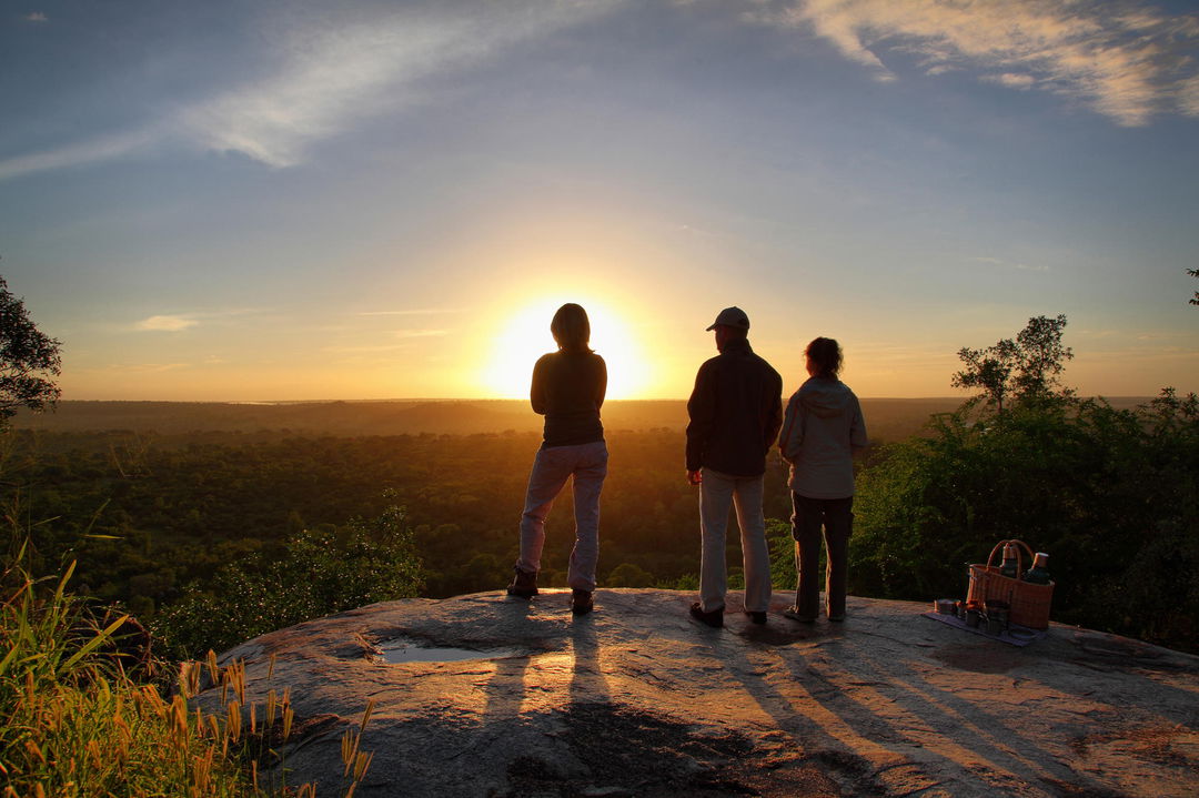 guests on rocky outcrop at sunset looking at ravine below at Malamala reserve