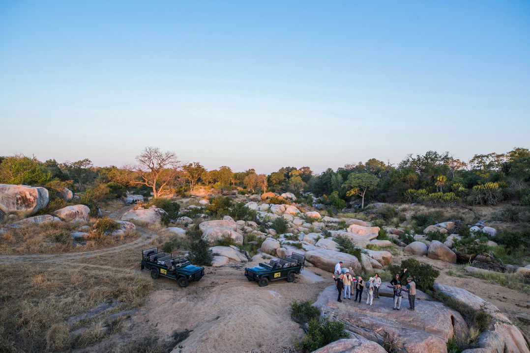 guest on a game drive stopping for sundowners in the river by MalaMala