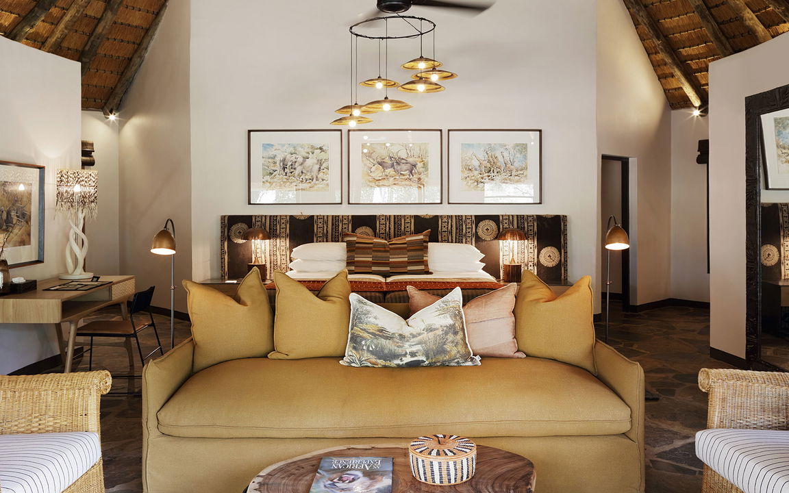 couch in bedroom of suite at Sable Camp MalaMala