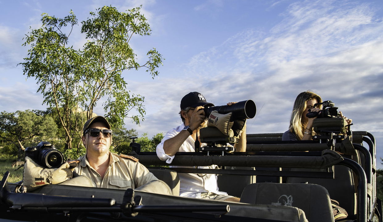 photographic safari with guests and guide on vehicle at MalaMala game reserve