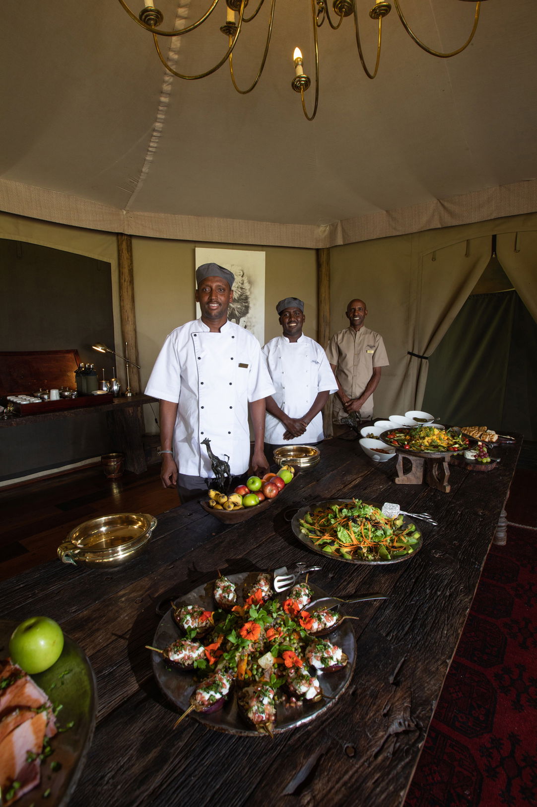 chefs with food in serving area of Mara Plains Camp Kenya Masai Mara