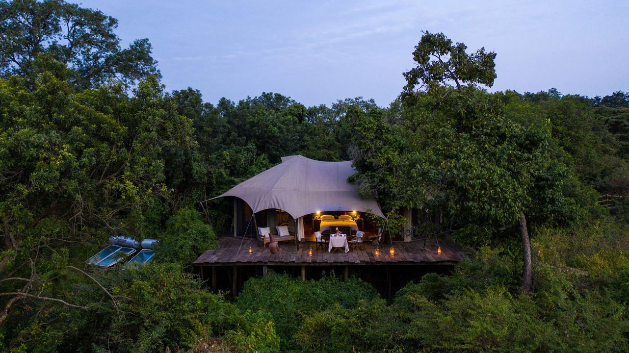 suite at dusk with dining setup on deck at Mara Plains Camp Kenya Masai Mara