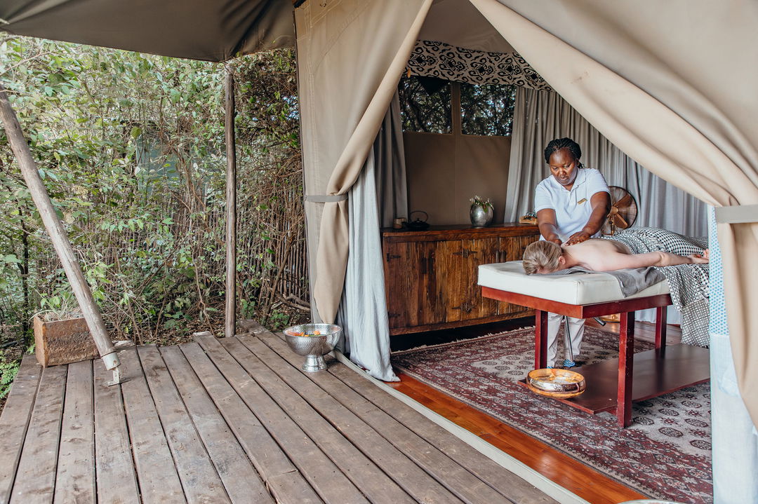 lady guest getting message in room of Mara Plains Camp Kenya Masai Mara