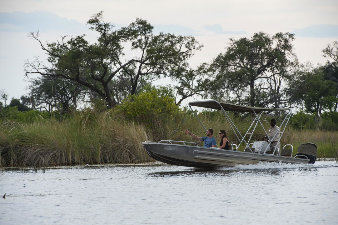 motorboat cruising on waterways of delta at Vumbura Plains Camp Wilderness Okavango Delta