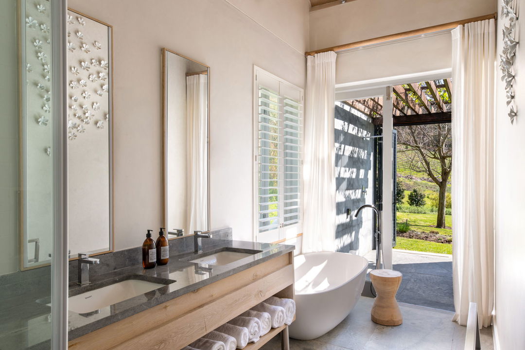 bathroom and vanity view with open doors to patio at Mont Rochelle Wine Estate