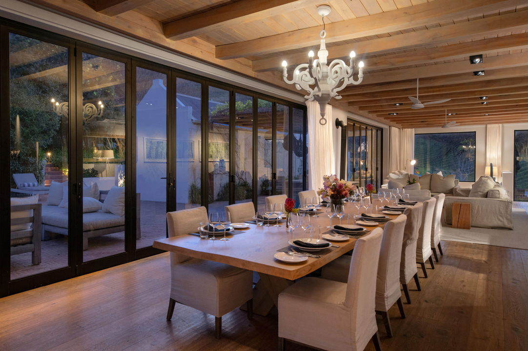 long dining table set for guest dinner at night by Mont Rochelle Wine Estate