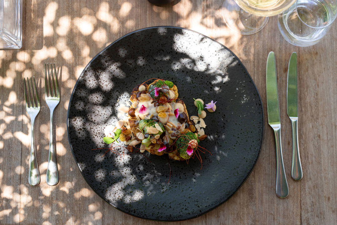 gourmet food on black plate served at Mont Rochelle Luxury Hotel in Franshoek