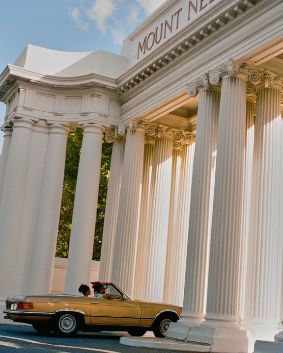 Mercedes cabriolet under big entrance pillars by gate of Mount Nelson Hotel Cape Town