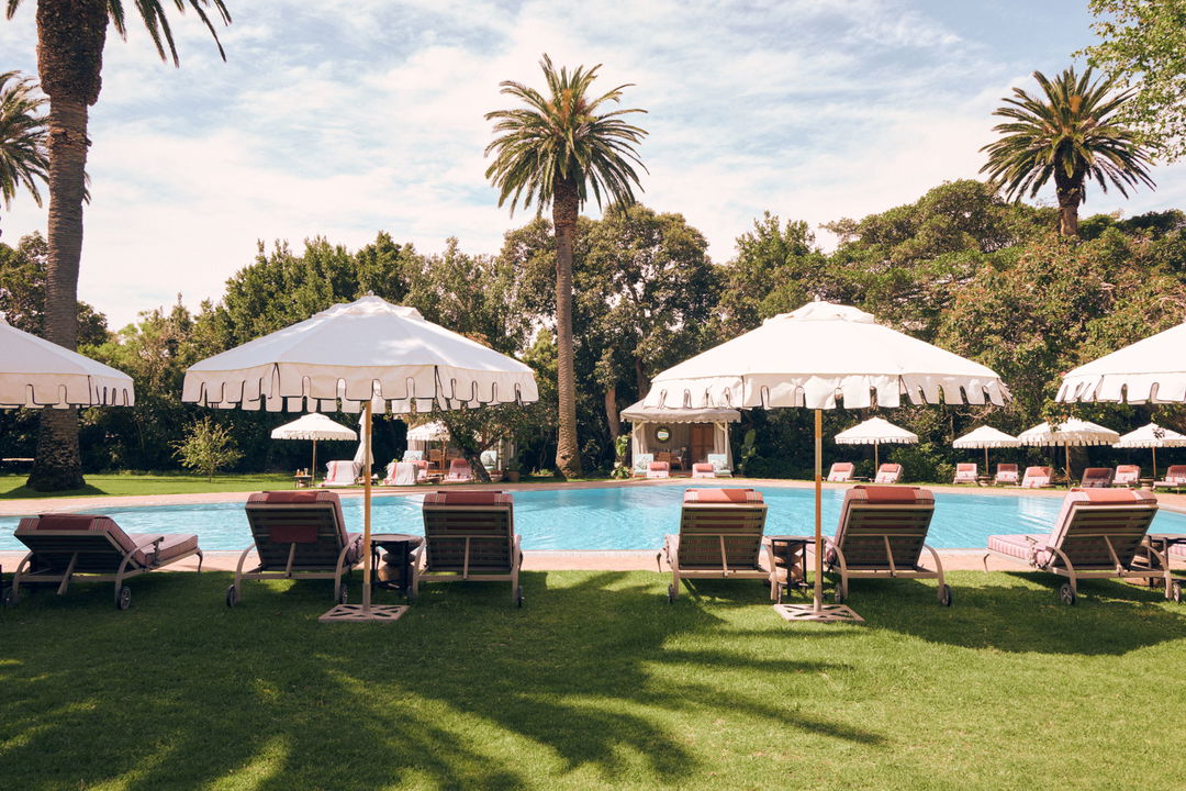 loungers under umbrellas at the pool of Mount Nelson Hotel Cape Town