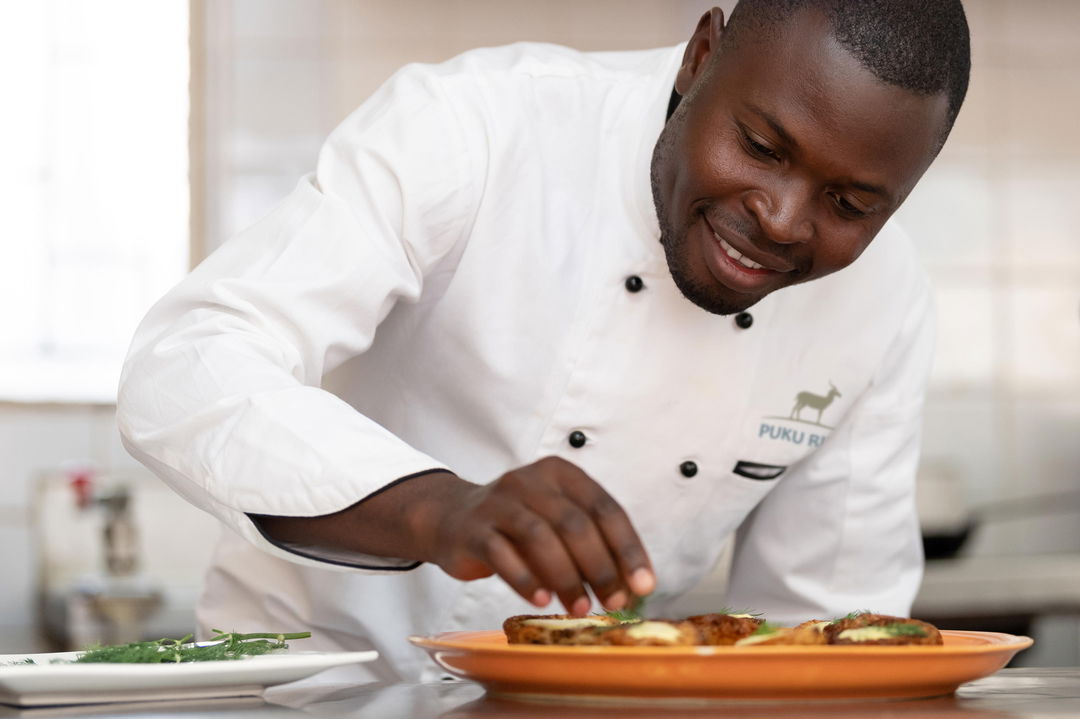 chef preparing food for guests at Puku Ridge Camp Zambia