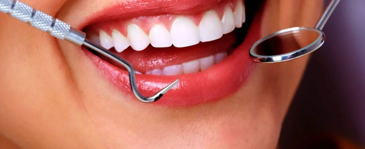 dental tools near mouth smiling wide