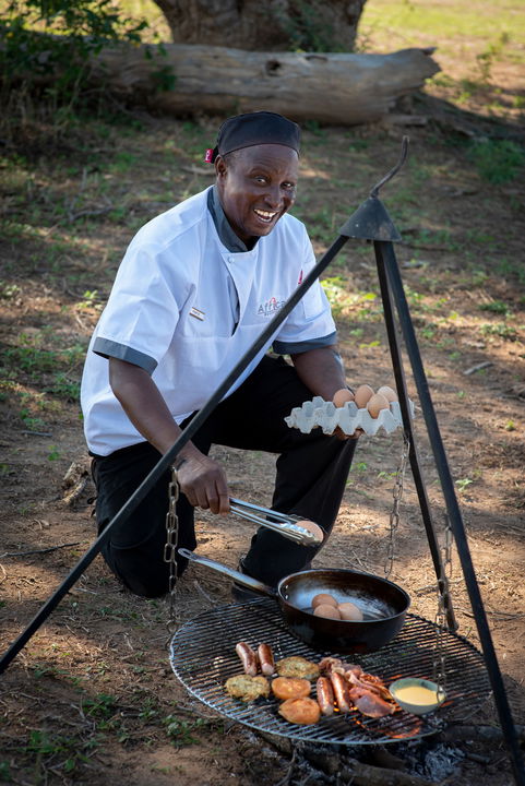 chef preparing break fast in the bush by Nyamatusi Camps Mana Pools Zimbabwe 