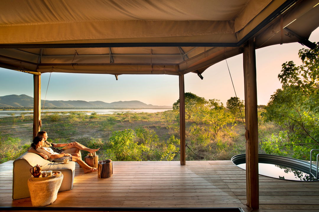 couple on the deck outside tented suite at Nyamatusi Camps Mana Pools Zimbabwe 