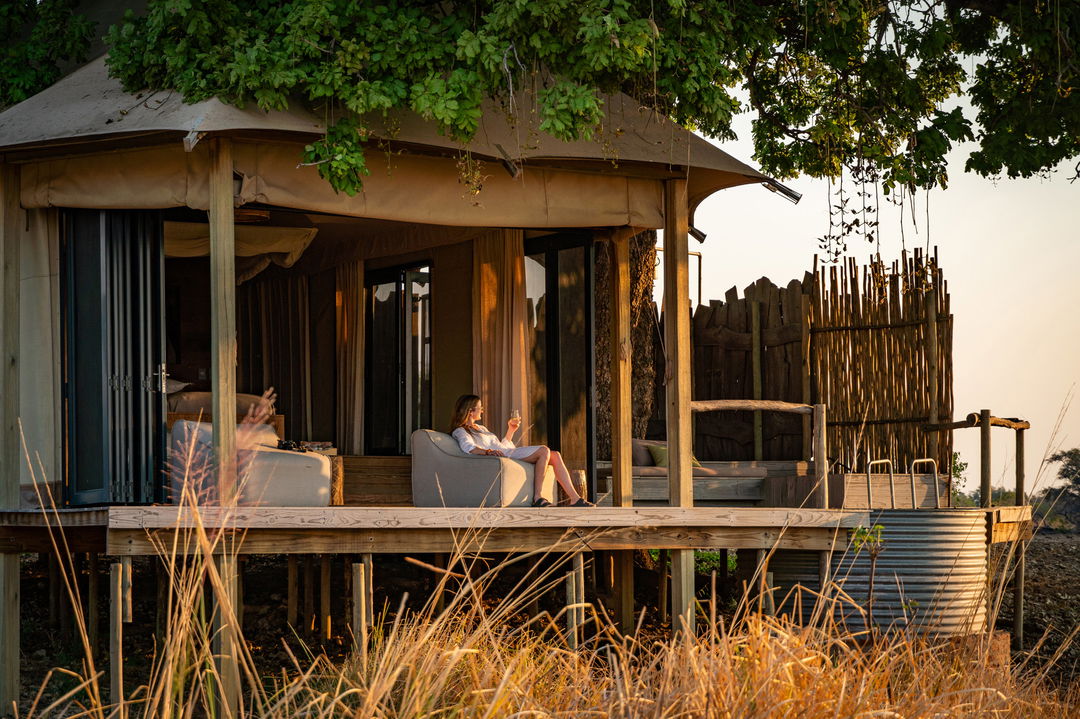 lady sitting on deck of suite looking beyond at Nyamatusi Camps Mana Pools Zimbabwe 