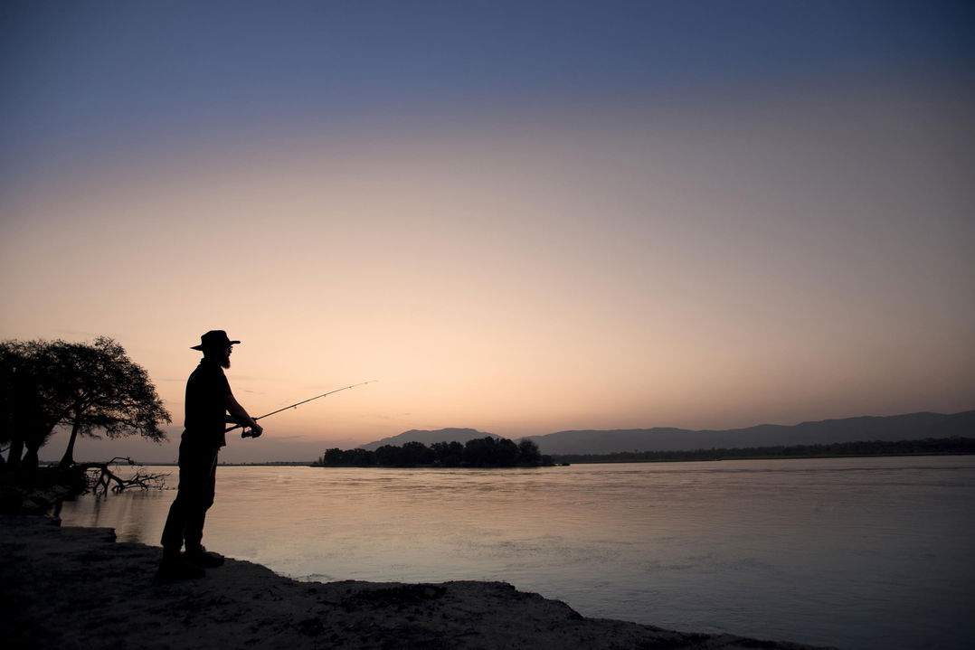 guest fishing n banks of river by Nyamatusi Camps Mana Pools Zimbabwe 