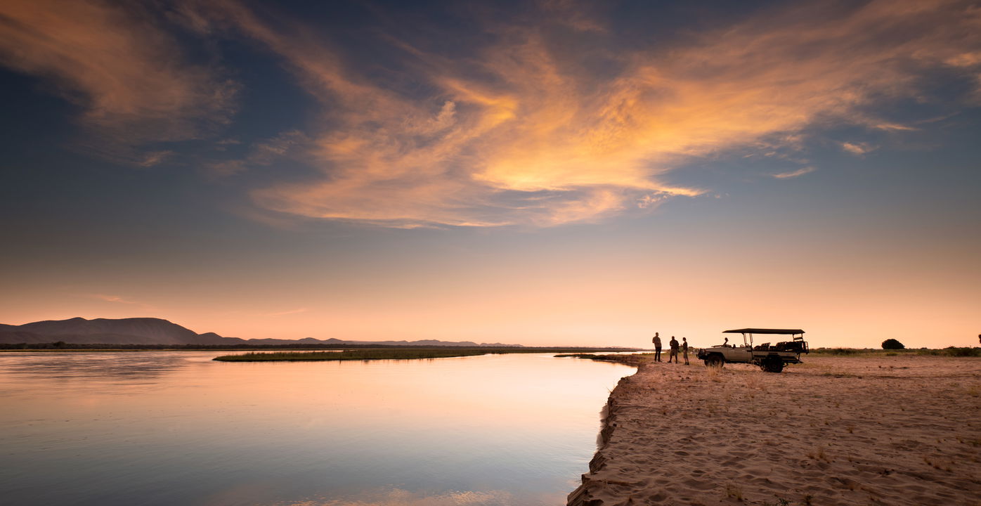 safari vehicle at sunset on banks of pools by Nyamatusi lodge mana pools