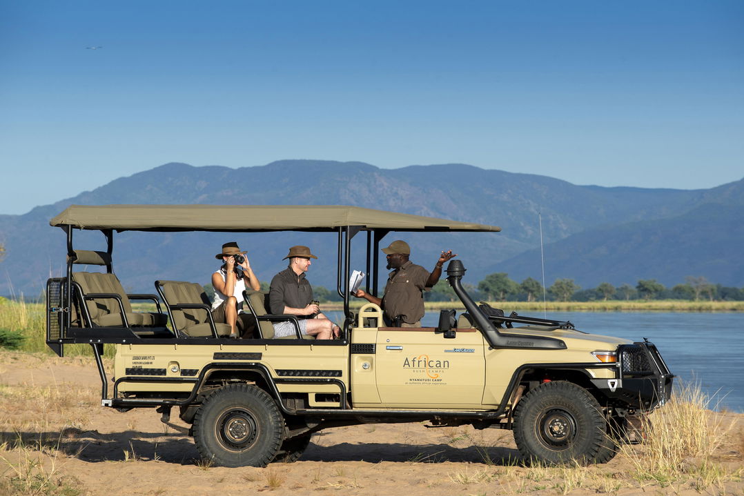 guests on a game drive in the vehicle of Nyamatusi Camps Mana Pools Zimbabwe  near river
