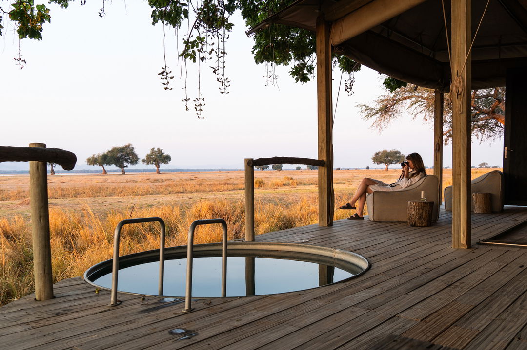 splash pool with guest seated on deck of suite at Nyamatusi Camps Mana Pools Zimbabwe 