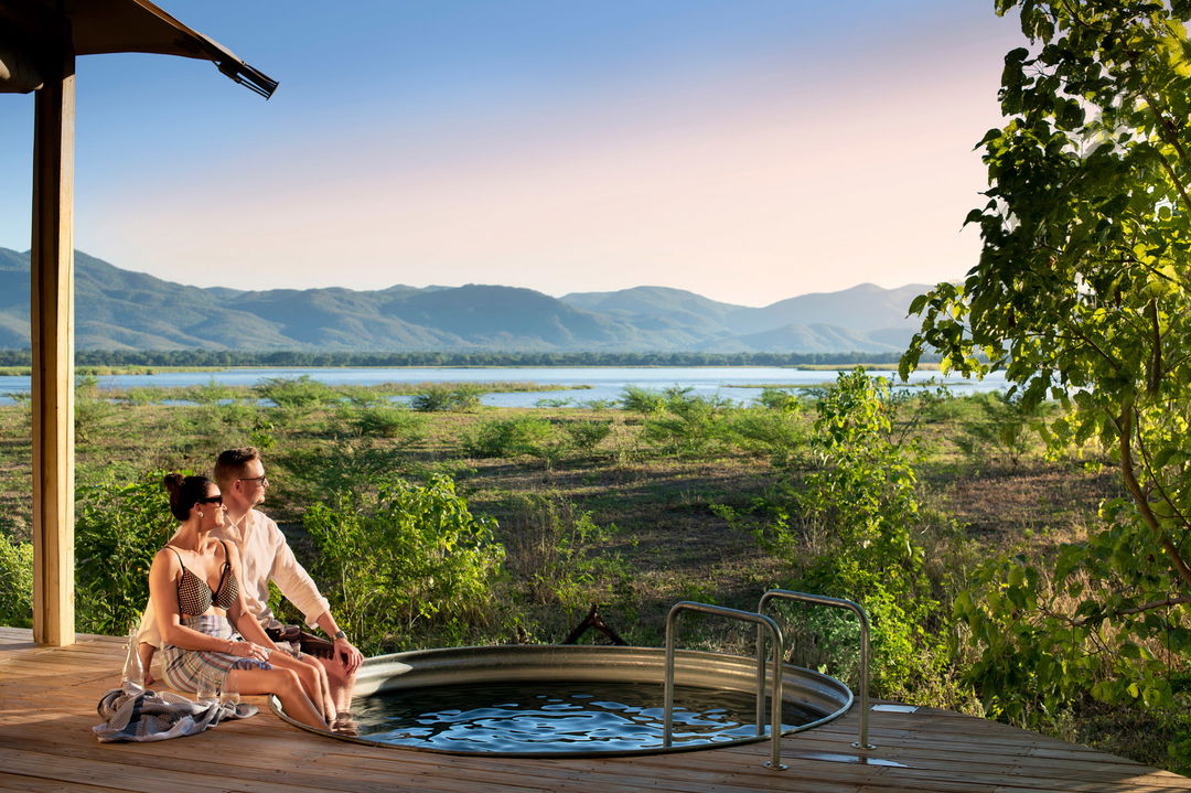 couple in splash pool on deck of suite by Nyamatusi Camps Mana Pools Zimbabwe 