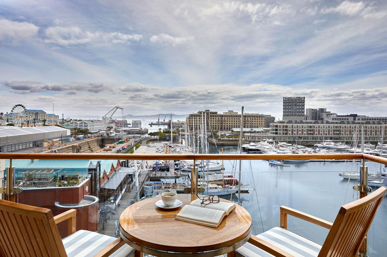 table and chairs on patio overlooking waterfront at one&only hotelcape town