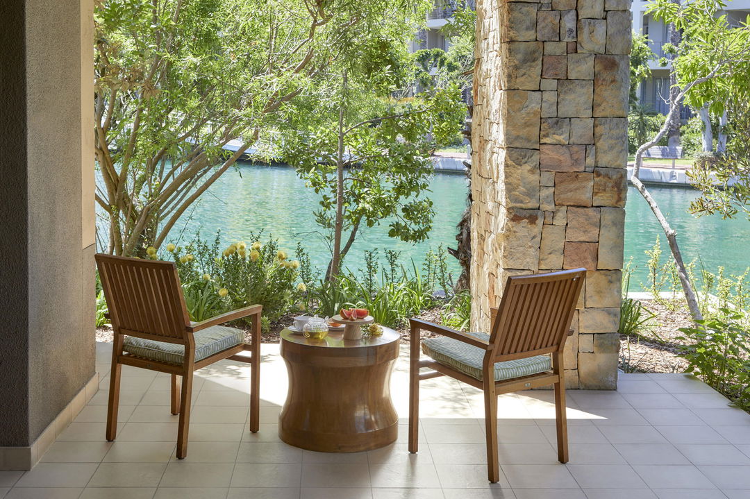 table and chairs on patio of room with canal views at One&Only Resort Waterfront Cape Town
