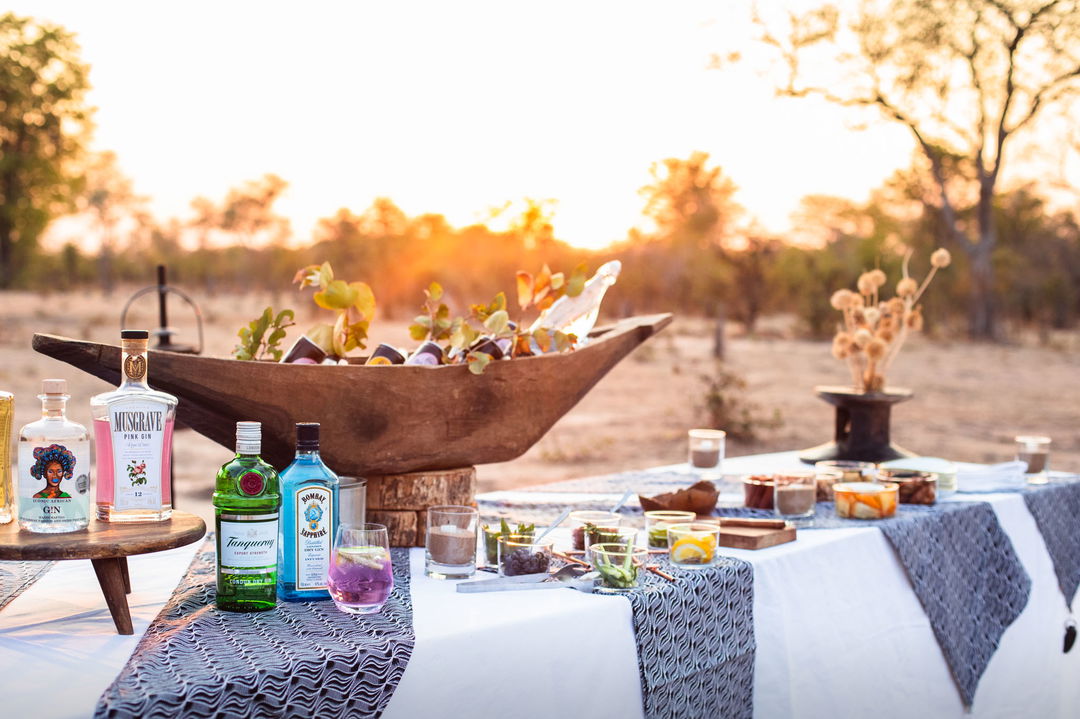 sundowner drinks on table in bush for guests at Puku Ridge Camp Zambia