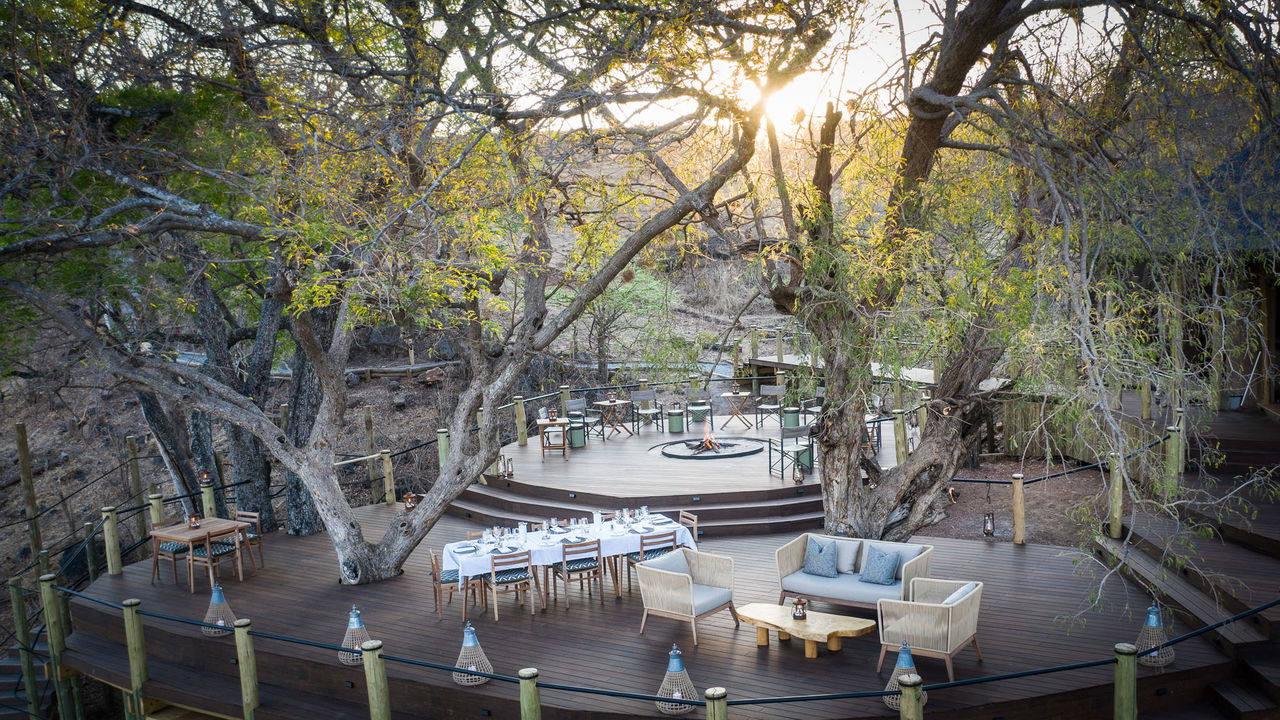 viewing deck with tables and firepit of main lodge puku ridge Zambia