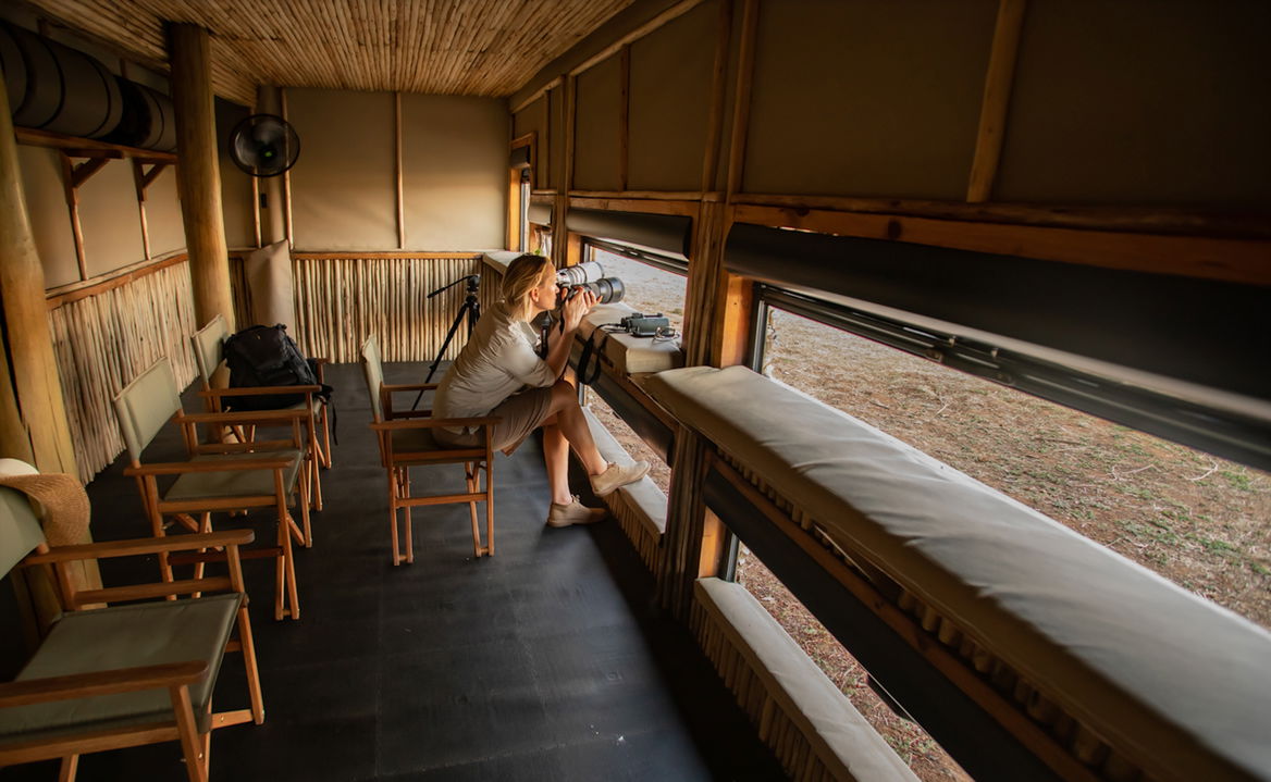 lady with camera inside hide at Puku Ridge Camp Zambia Luangwa Plains